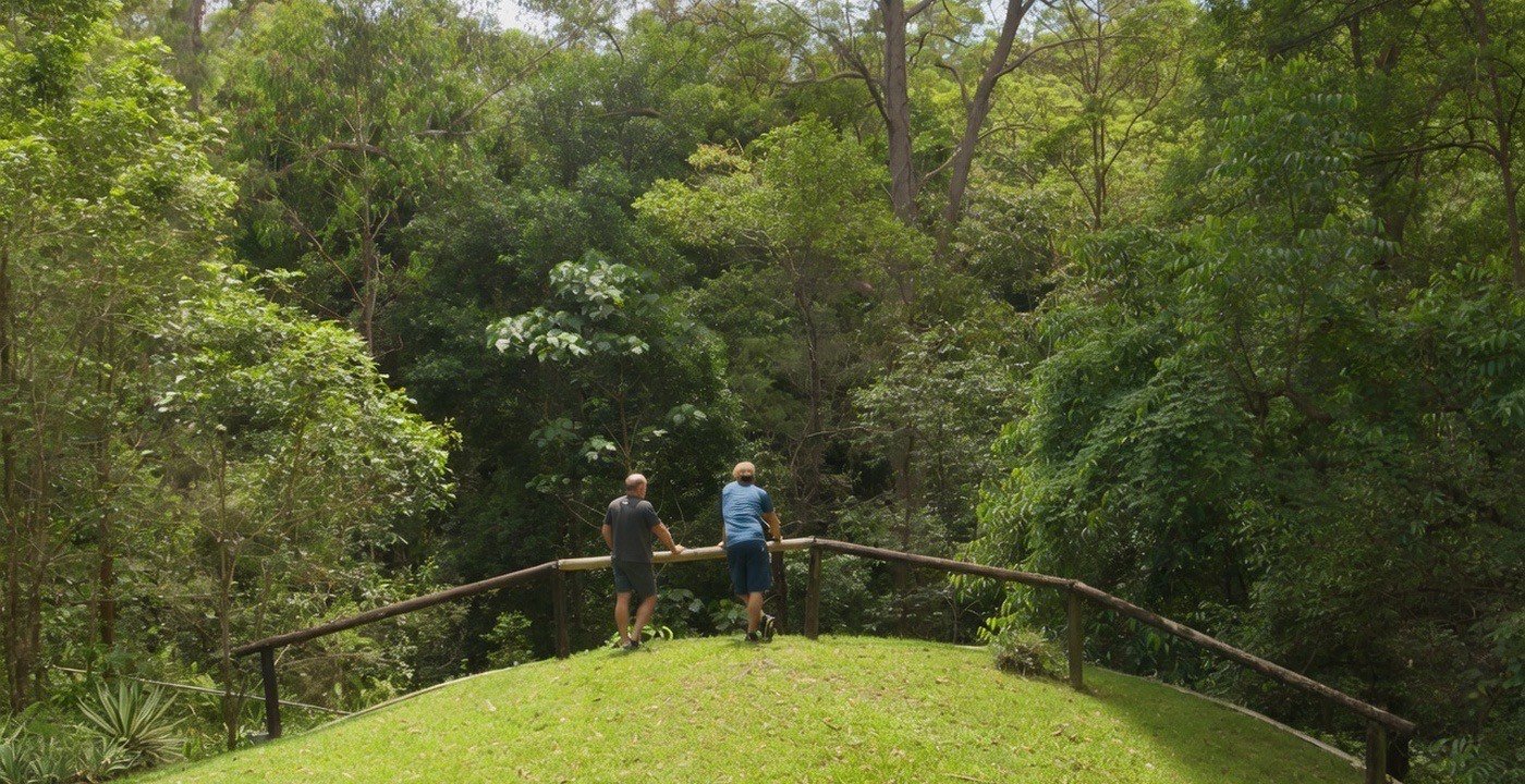 Two people overlooking the forested grounds at WHOS.
